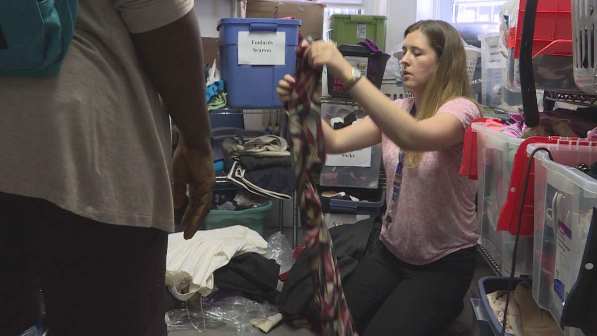 Alannah Gibson, a case worker at Chez Doris, helps sort out donated clothes at the centre.