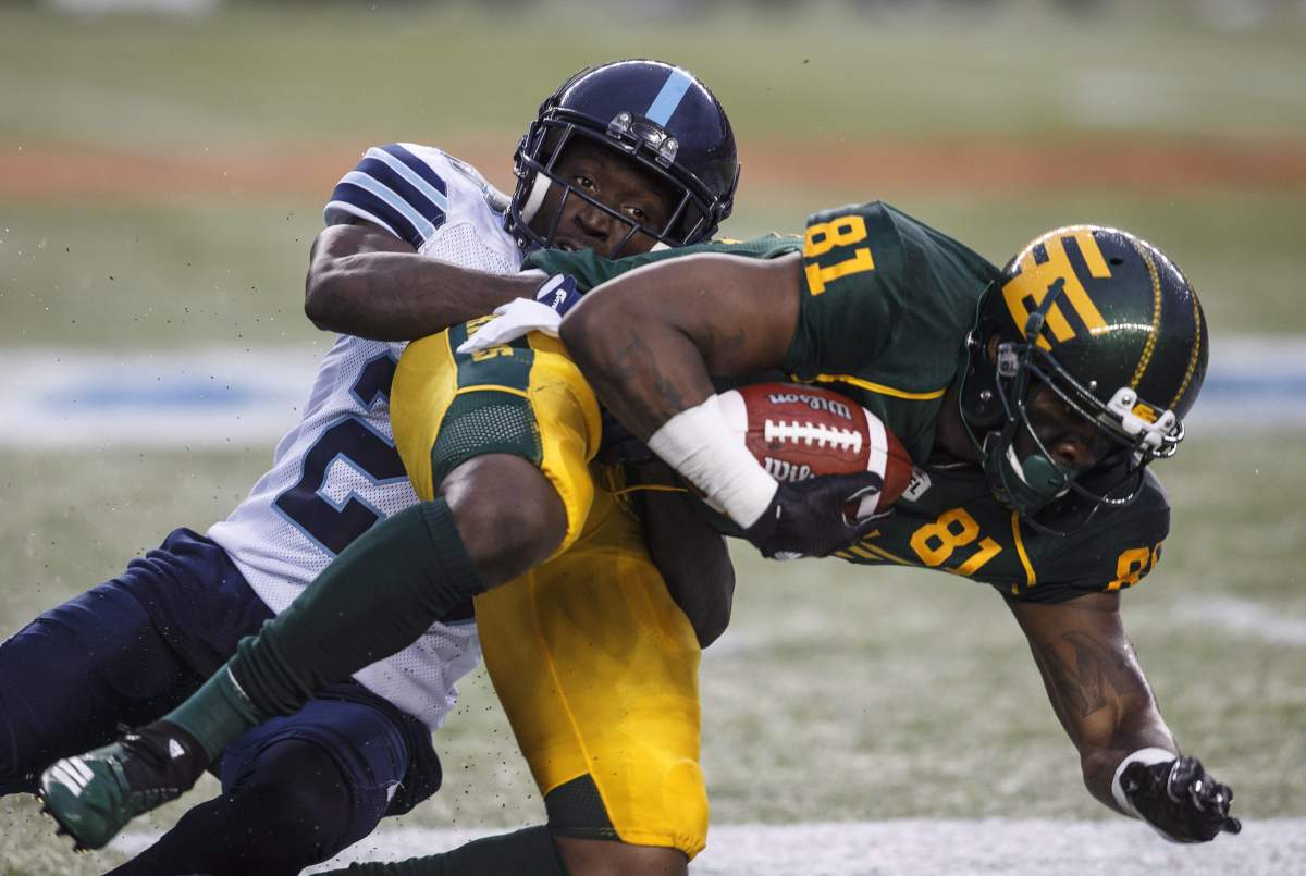 Toronto Argonauts Cassius Vaughn (26) tackles Edmonton Eskimos D'haquille Williams (81) during first half CFL action in Edmonton, Alta., on Friday July 13, 2018. 