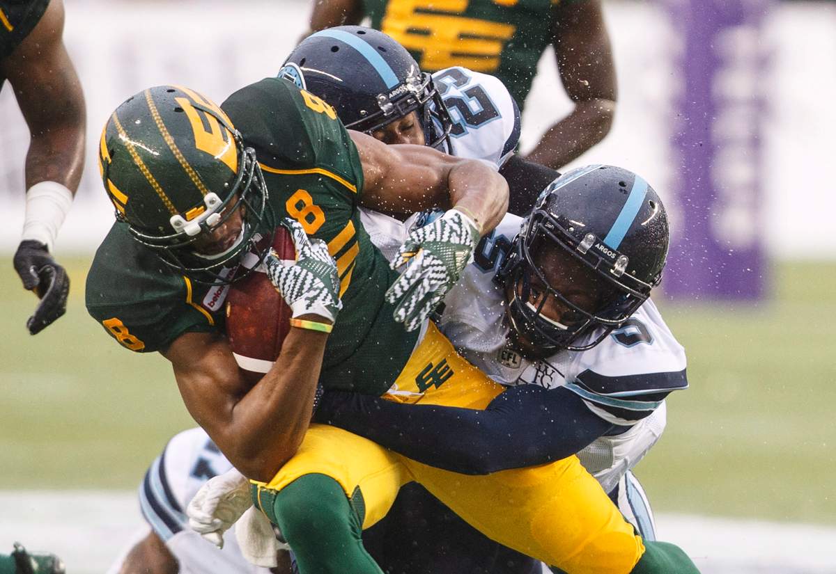Toronto Argonauts Jermaine Gabriel (5) tackles Edmonton Eskimos Kenny Stafford (8) during first half CFL action in Edmonton, Alta., on Friday July 13, 2018.