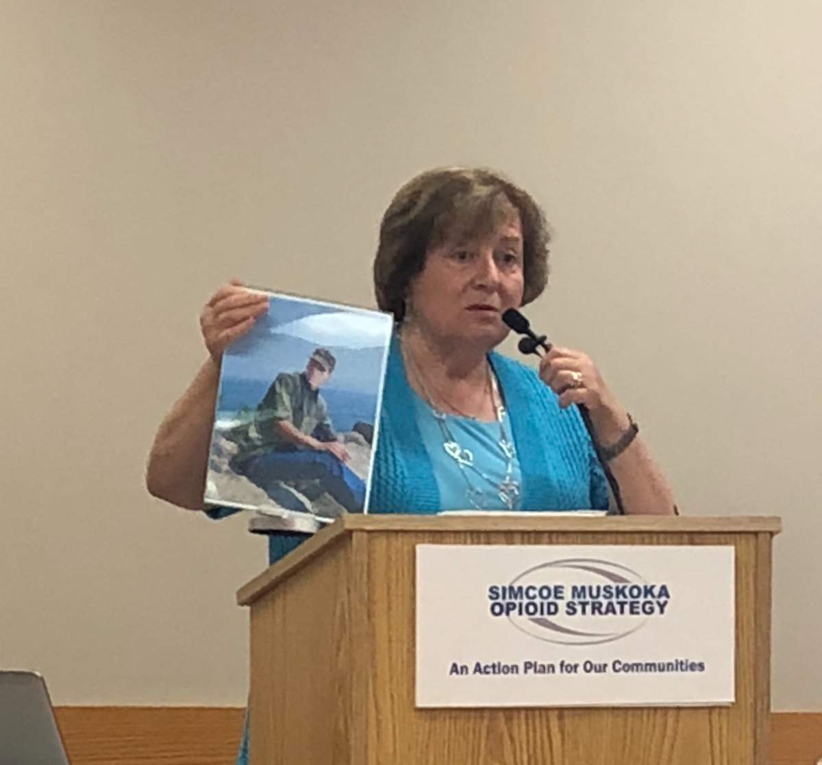 Evelyn Pollock holds up a photo of her son who tragically died of an opioid overdose in 2017.