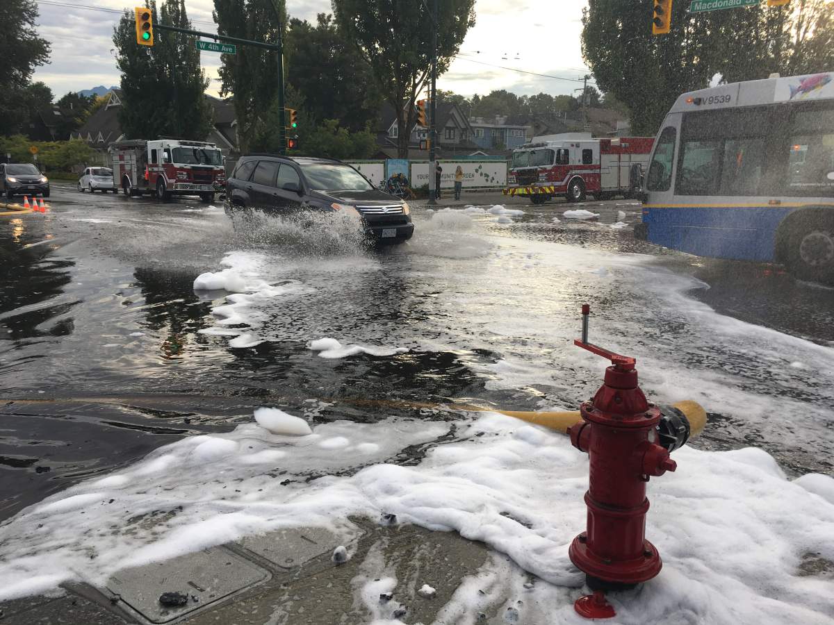 Water is pouring down West 4th Avenue in Kitsilano Thursday as crews battle a big fire nearby. Credit: Jamie Myers