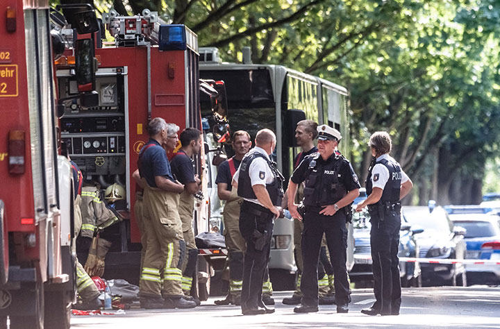 Policemen stand near a public service bus in Kuecknitz near Luebeck northern Germany, after several people were injured in the bus in an assault by a man wielding a knife on July 20, 2018. 