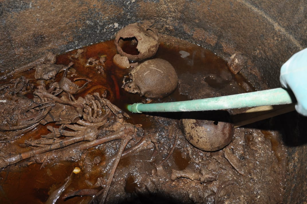 A handout picture released on July 19, 2018, by the Egyptian Antiques ministry shows skeletons in the black granite sarcophagus uncovered early this month in the Sidi Gaber district of Alexandria, filled with sewage water.