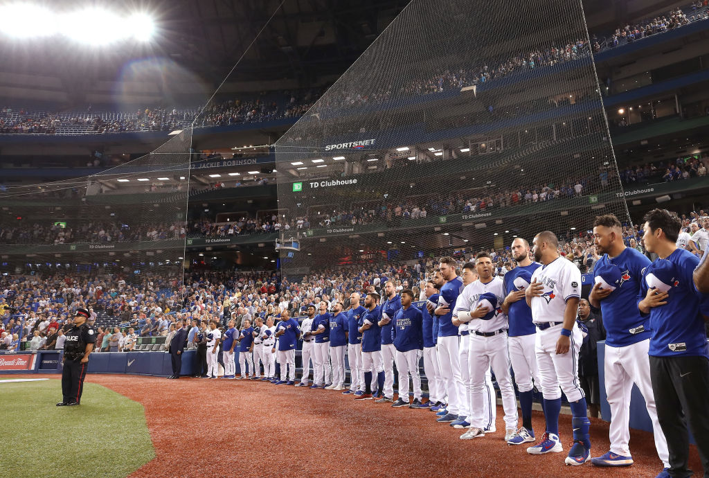 Toronto Blue Jays players stand in tribute to the victims of the Danforth shooting Sunday night before the start of the Toronto Blue Jays MLB game against the Minnesota Twins at Rogers Centre on Monday in Toronto.