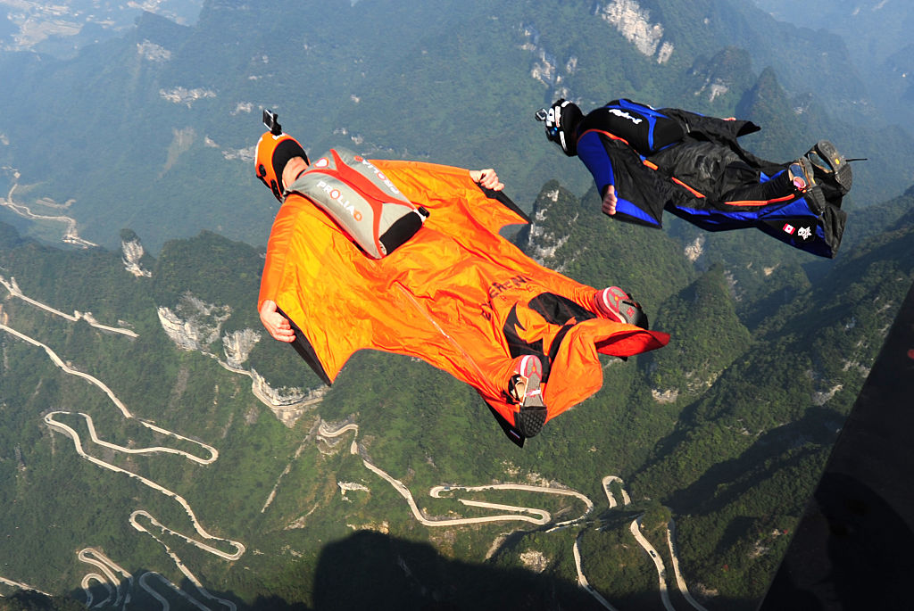 Two participants in wingsuit fly above Tianmen Mountain at ZZHANGJIAJIE Scenic Spot during knockout game of the 4th Red Bull WWL China Grand Prix on October 17, 2015 in ZZHANGJIAJIE, Hunan Province of China.