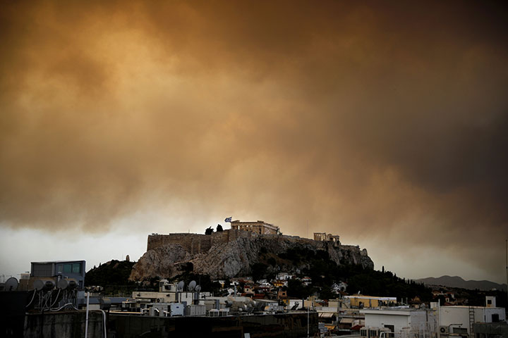 Smoke from a wildfire burning outside Athens is seen over the Parthenon temple atop the Acropolis hill in Athens, Greece, July 23, 2018.