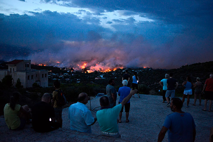 People watch a wildfire in the town of Rafina, near Athens, on July 23, 2018.