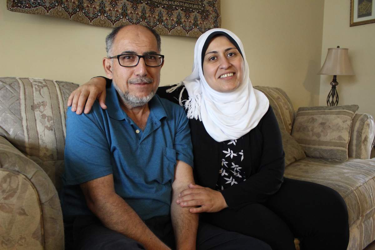 Rajaie "Roger" El Shorafa and his wife, Manal Baliha, sit on a couch inside their west-London home, ten months after El Shorafa was assaulted outside the convenience store he ran for 20 years. 