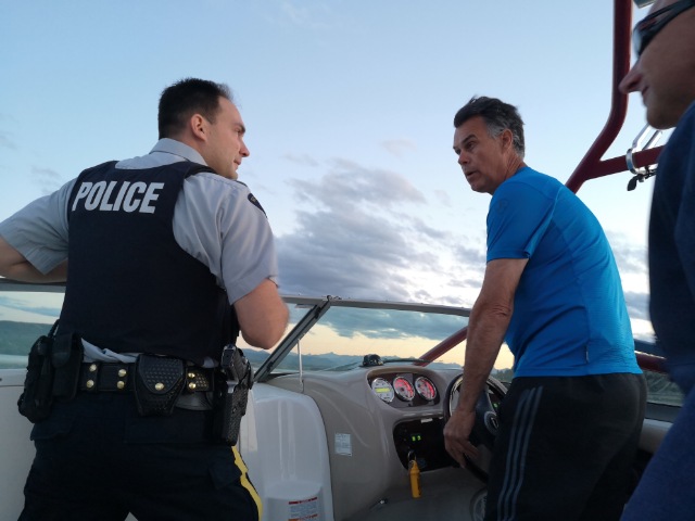 An RCMP member and a Good Samaritan worked together Saturday night to help rescue 10 people whose boat had sunk in Ghost Lake, located west of Calgary. July 14, 2018.
