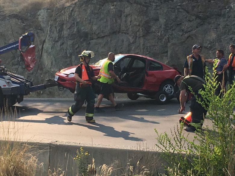 Emergency crews remove the wreckage of a vehicle involved in a crash Monday afternoon on Highway 97 north of Peachland. 