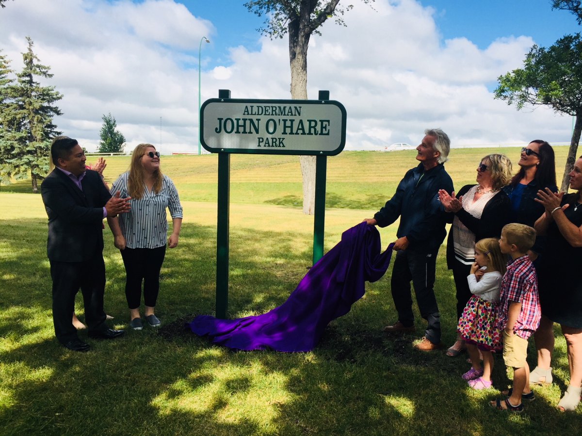 Alderman O'Hare's family members, along with Coun. Mike Pagtakhan (left), show off the park's new sign.