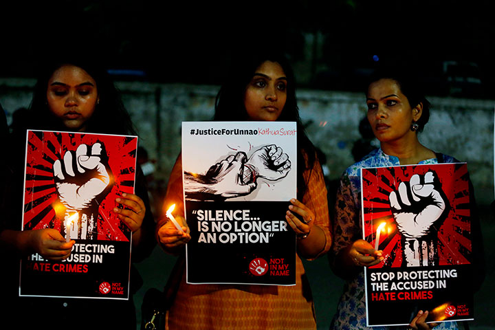 In this April 16, 2018 file photo, Indian women hold candles and placards during a protest against two recently reported rape cases, in Ahmadabad, India. 