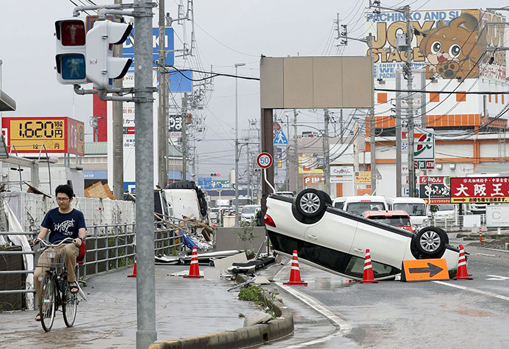 An overturned car remains on a street after heavy rain in Ozu, Ehime Prefecture, Japan, in this photo taken by Kyodo July 8, 2018.