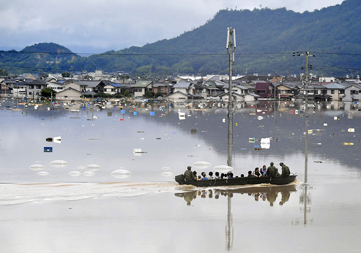 Residents are rescued from a flooded area by Japan Self-Defense Force soldiers in Kurashiki, southern Japan, in this photo taken by Kyodo July 7, 2018.