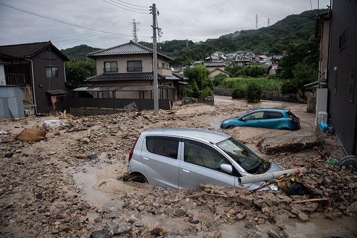 Cars pictured trapped in the mud after floods in Saka, Hiroshima prefecture on July 8, 2018.