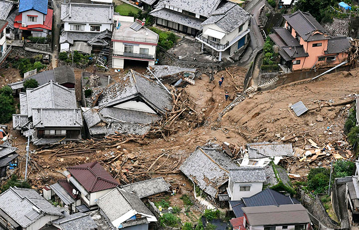 Houses are damaged by a mudslide following heavy rains in Kure city, Hiroshima prefecture, southwestern Japan, July 7, 2018.