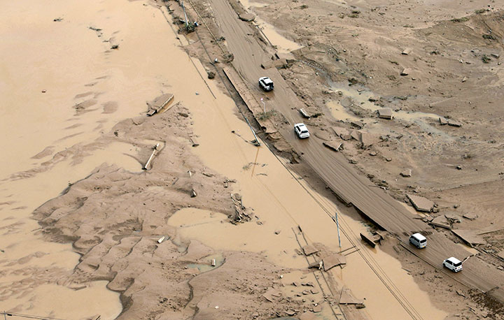 Cars move along a road covered with mud after heavy rain in Mabi town in Kurashiki, Okayama Prefecture, Japan, in this photo taken by Kyodo July 9, 2018.