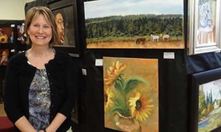 Laurie Ryan stands beside some of her paintings. The West Kelowna artist is being remembered as talented, kind and wonderful.