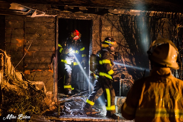 Firefighters inspect part of The Log Cabin Motel in Penticton after dousing a three-alarm fire this morning.