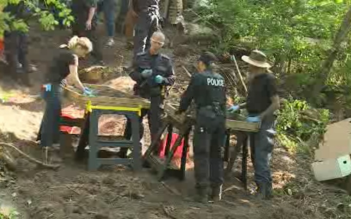 Police sift through dirt for human remains near the property at Mallory Crescent in Toronto linked to accused serial killer Bruce McArthur on July 5, 2018.