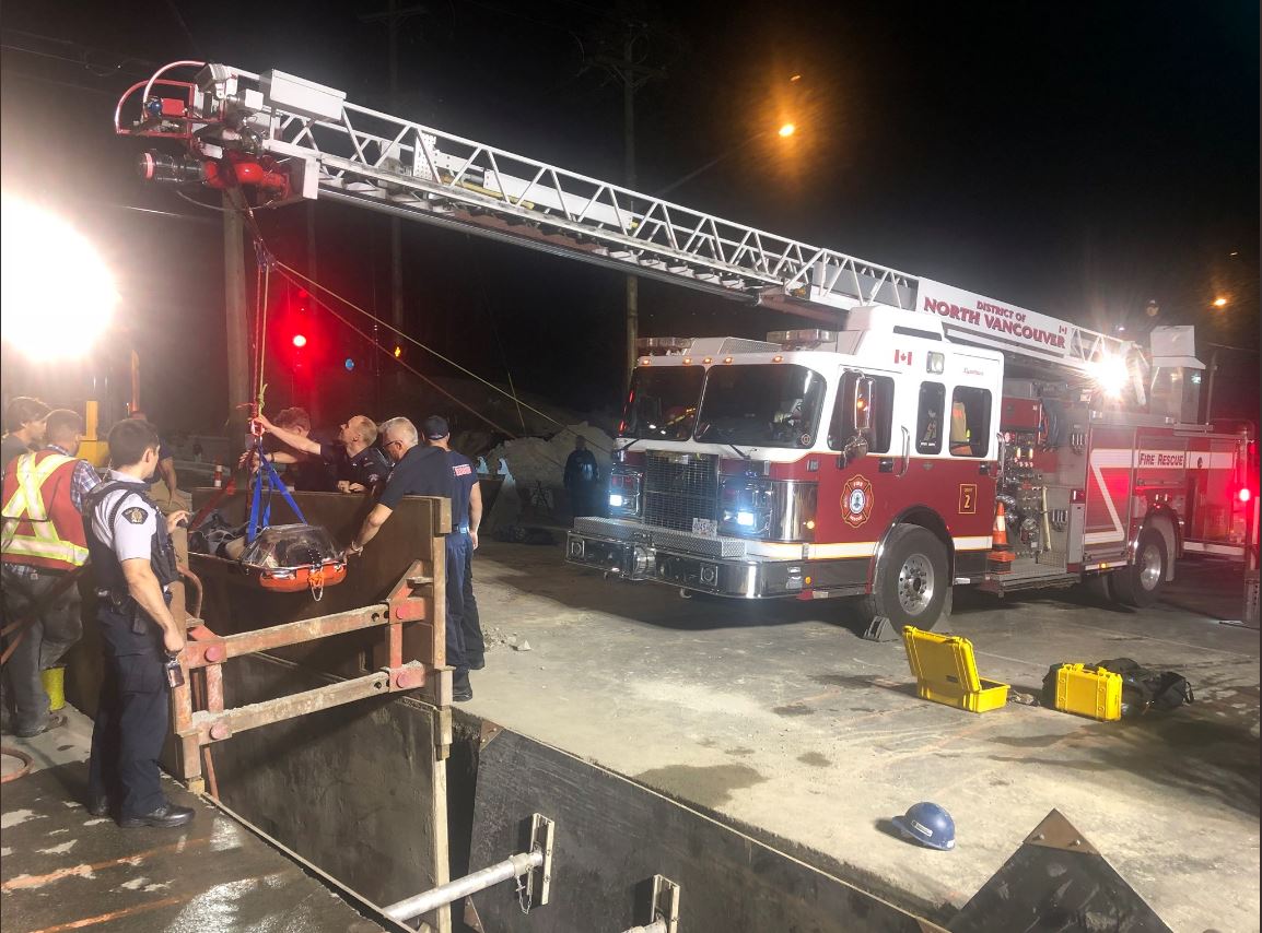 Firefighters lift the injured man out of a deep trench at a construction site in North Vancouver early Saturday morning.