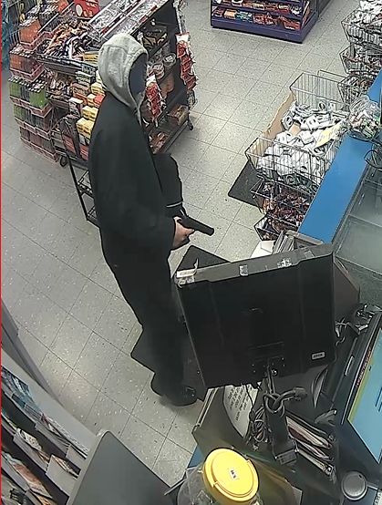 A suspect points what police believe is a gun during a robbery at a Strathcona County gas station, Tuesday, July 3, 2018.