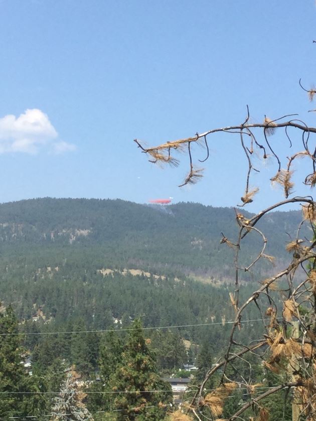 A plane drops retardant on a fire in the hills above Glenrosa in West Kelowna on Saturday afternoon.