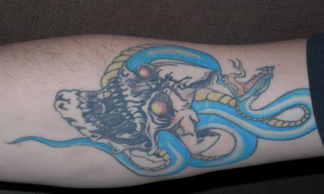 Police say Russell has several tattoos, including a skull with a snake coming out of it on his right forearm