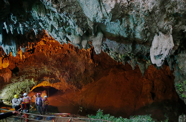 Rescue personnel walk out of the entrance to a cave complex where 12 soccer team members and their coach went missing, Thursday, June 28, 2018, in Mae Sai, Chiang Rai province, in northern Thailand.