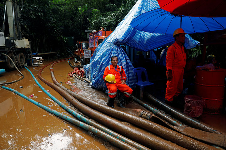 Rescue workers pass their time in front of the Tham Luang cave complex, as members of an under-16 soccer team and their coach have been found alive, in the northern province of Chiang Rai, Thailand, July 3, 2018.