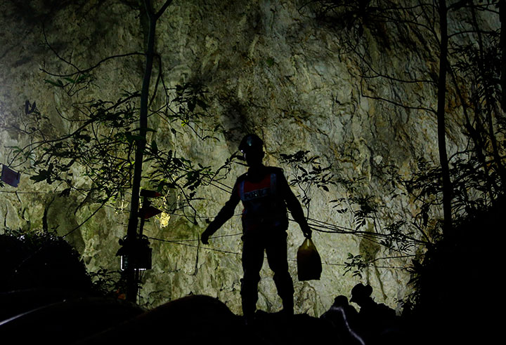 Rescuers make their way down at the entrance to a cave complex where 12 boys and their soccer coach went missing, in Mae Sai, northern Thailand, July 1, 2018.