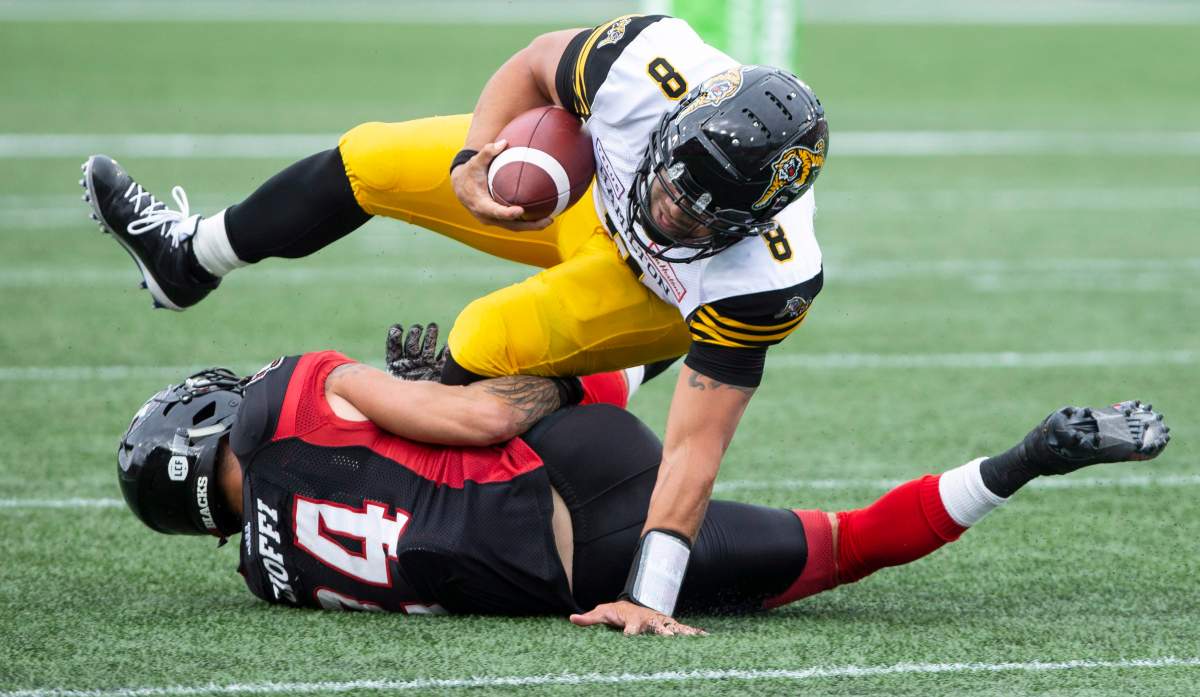 Hamilton Tiger-Cats quarterback Jeremiah Masoli (8) is taken down by Ottawa Redblacks Anthony Cioffi during second half CFL Football game action in Hamilton, Ont. on Saturday, July 28, 2018.