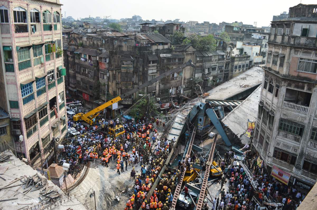 Indian soldiers, rescue workers and volunteers try to free people trapped under the wreckage of a collapsed flyover bridge in Kolkata on March 31, 2016.