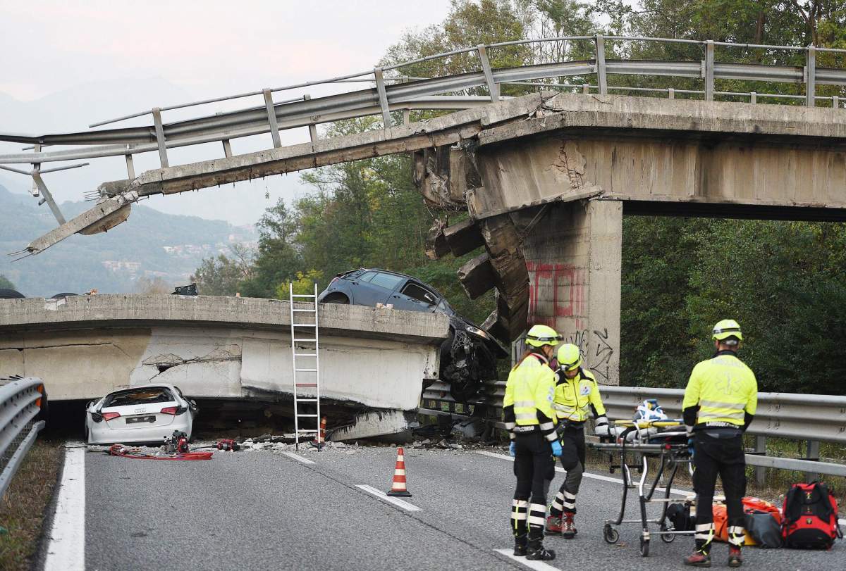 Italian emergency workers at the scene where one person was killed and four injured including three children when an overpass collapsed onto State Highway 36 between Milan and Lecco, Italy on 28 October 2016.