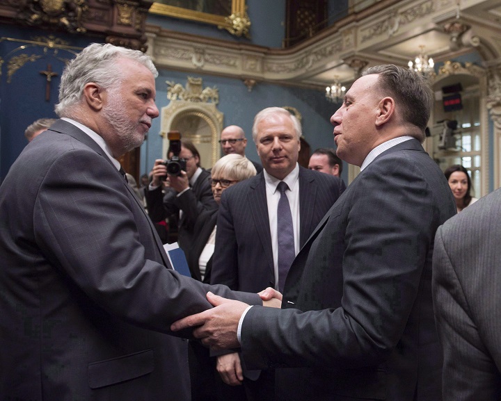 In this 2017 file photo, Quebec Premier Philippe Couillard, left, shakes hand with Coalition Avenir Québec Leader François Legault as Parti Québécois Leader Jean-François Lisée, centre looks on. Quebec unions prepare for election battle as top two parties seen as 'anti-worker.' Sunday, Aug. 12, 2018.