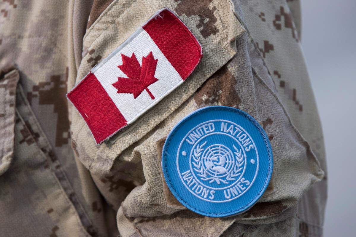 Canadian flag and the UN flag is shown on the sleeve of a Canadian soldier's uniform before boarding a plane at CFB Trenton in Trenton, Ontario, on Thursday July 5, 2018. 