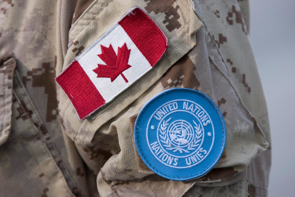 Canadian flag and the UN flag is shown on the sleeve of a Canadian soldier's uniform before boarding a plane at CFB Trenton in Trenton, Ontario, on Thursday July 5, 2018. 