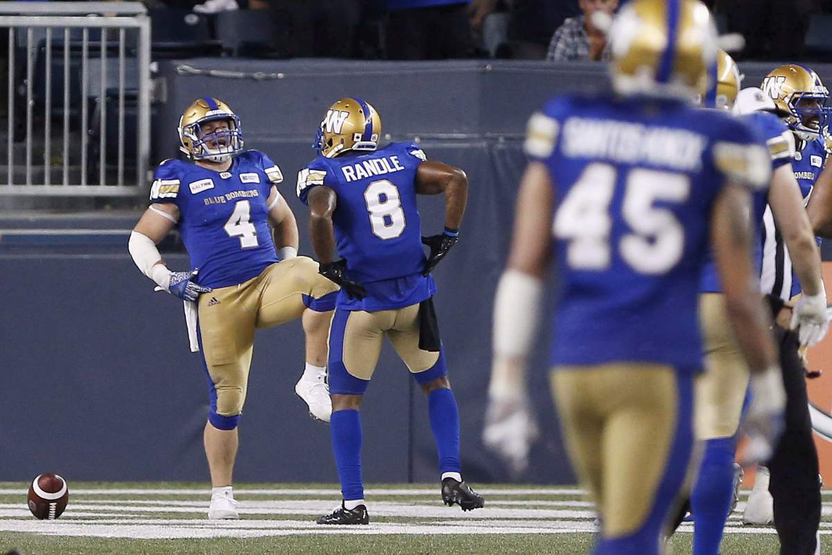 Winnipeg Blue Bombers' Adam Bighill (4) and Chris Randle (8) celebrate Bighill's interception and touchdown during second half CFL action against the BC Lions, in Winnipeg on Saturday, July 7, 2018. 