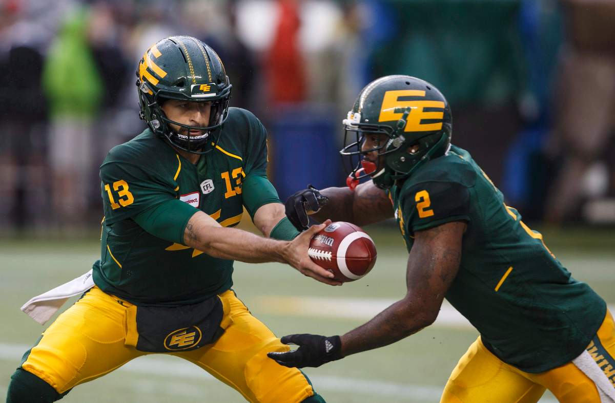 Edmonton Eskimos quarterback Mike Reilly (13) hands off to C.J. Gable (2) against the Toronto Argonauts during first half CFL action in Edmonton, Alta., on Friday July 13, 2018. 