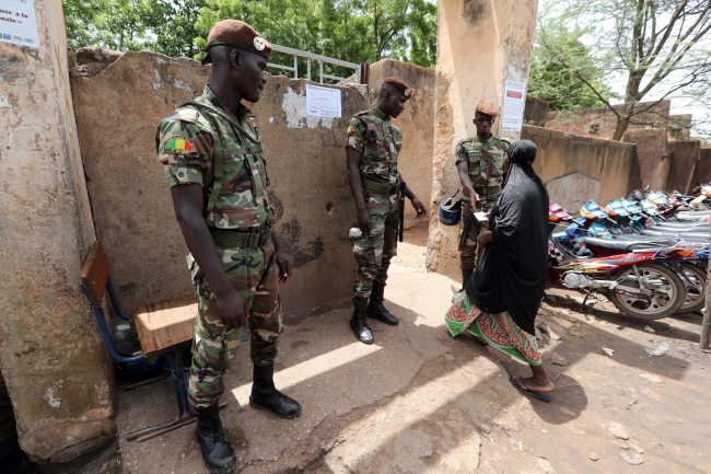 Malian soldiers stand guard at a polling station in Bamako, Mali, July 29, 2018.