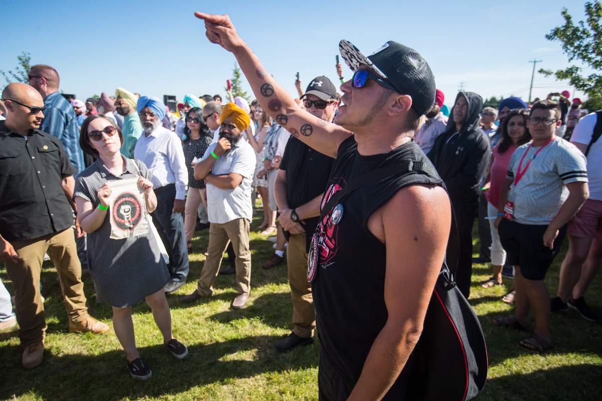 William George, a member of the Tsleil-Waututh First Nation and a guardian at the watch house near Kinder Morgan's Burnaby facility, shouts at Prime Minister Justin Trudeau as he speaks at a Liberal Party barbecue in Delta, B.C., on Sunday August 5, 2018. 
