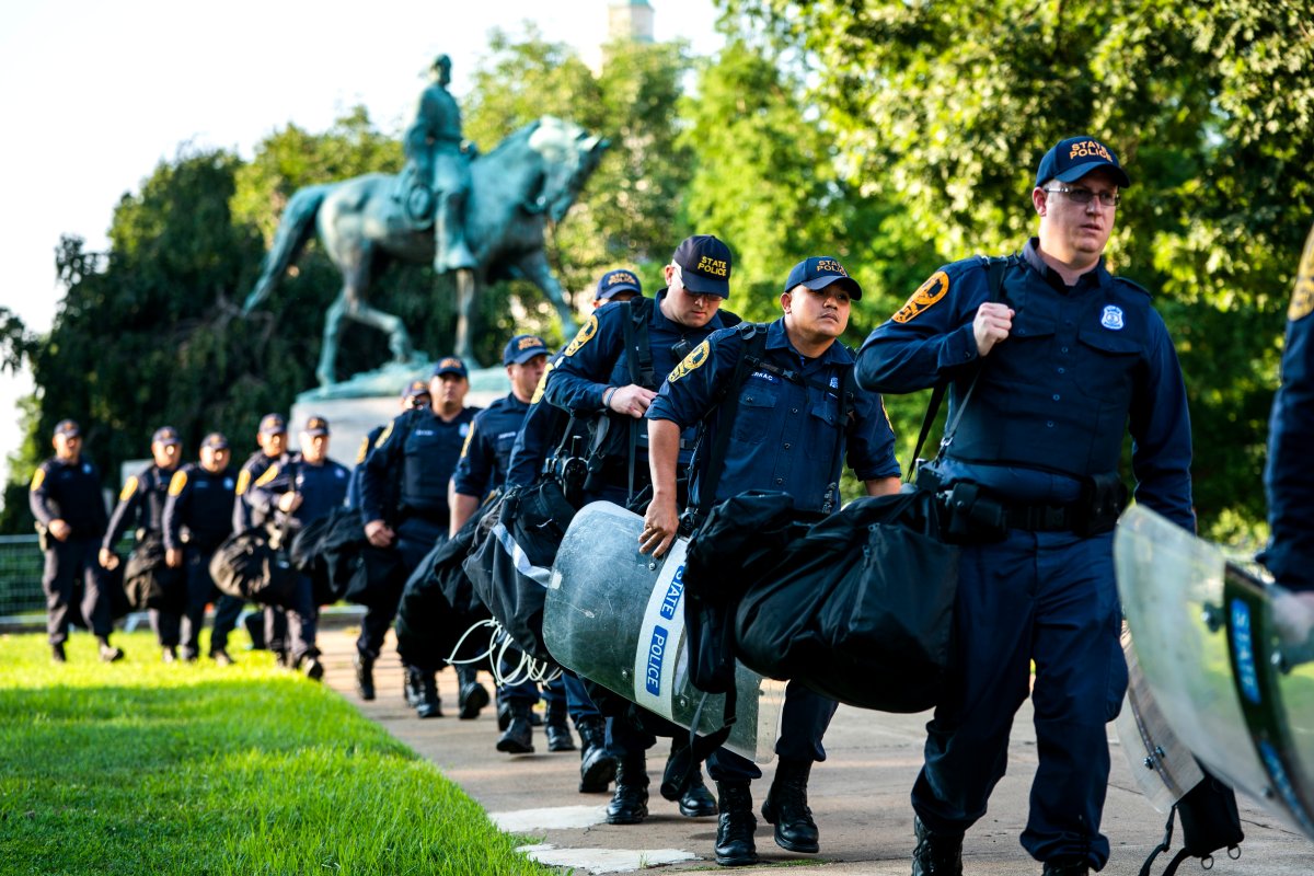 Police officers march past a statue of Confederate leader Robert E. Lee in Market Street Park as they set up a perimeter to prevent a repeat of last year's Unite the Right rally in downtown Charlottesville, Virginia, USA, 10 August 2018. 