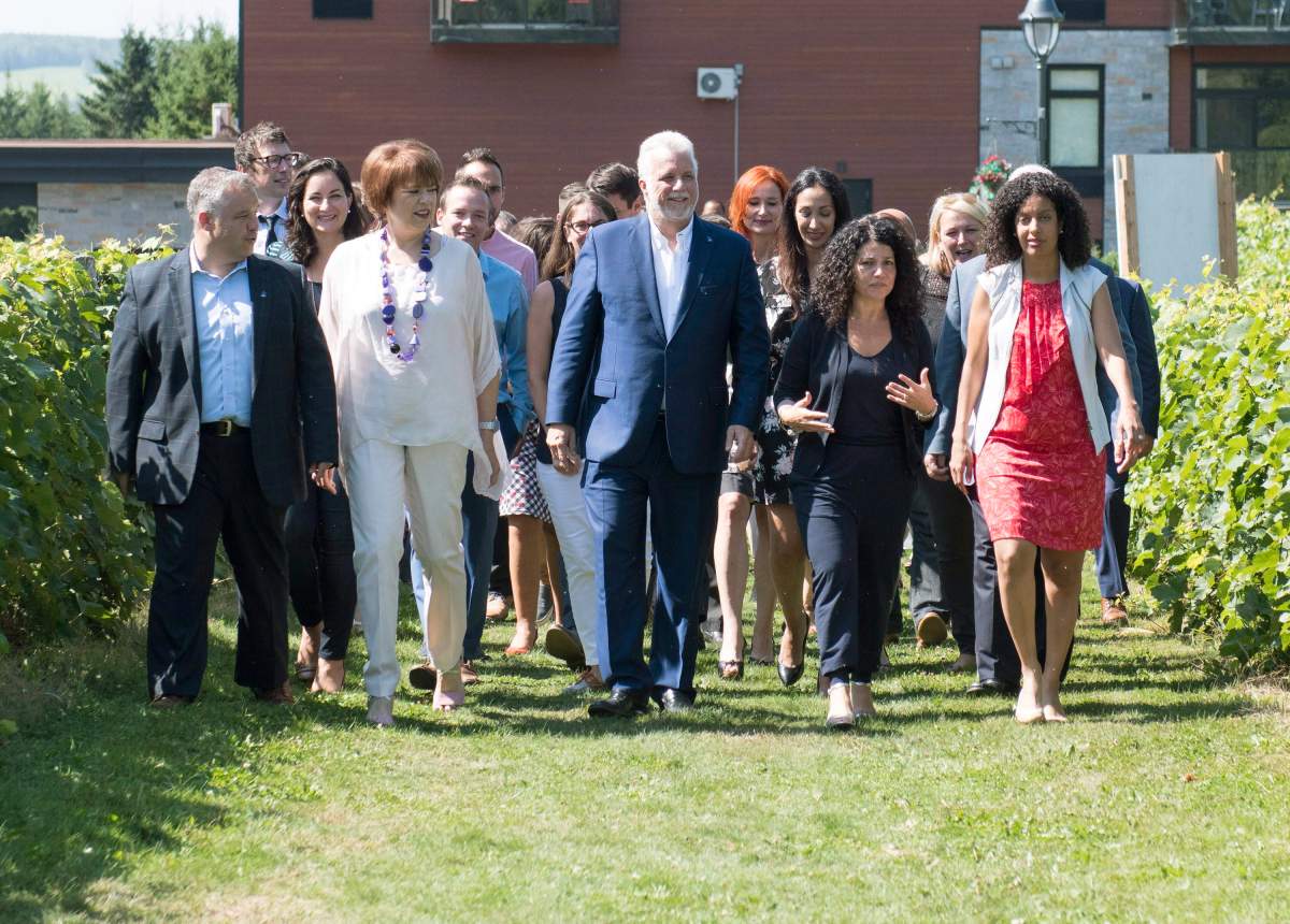 Quebec Liberal Leader Philippe Couillard, centre, walks in a vineyard with candidates in preparation for the general election, Monday, August 20, 2018 in Scott, Que. 