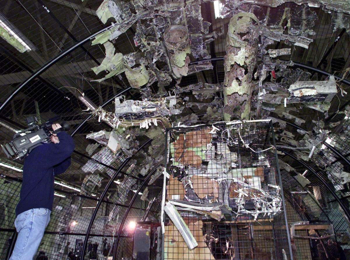 A journalist records the partially reconstructed forward section of Swissair Flight 111 at a news conference in Halifax on Monday, Dec. 4, 2000.