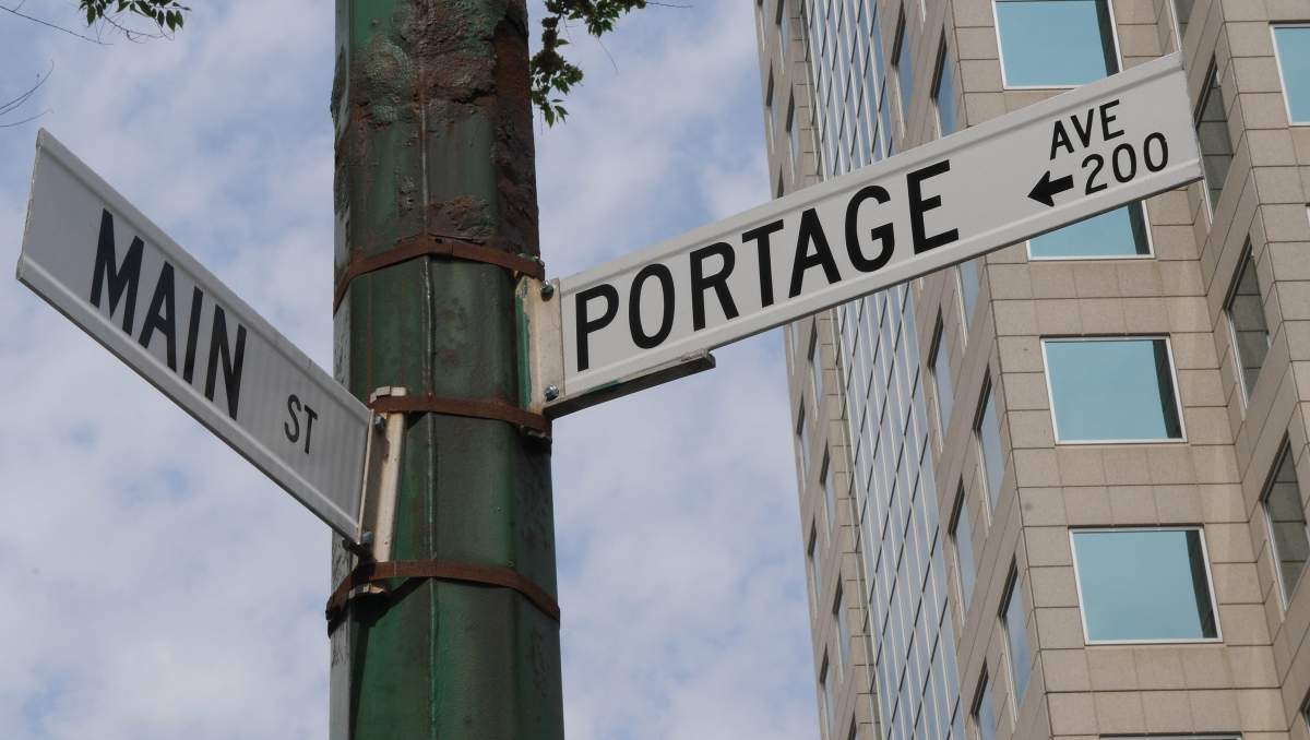 Streets signs for the intersection of Portage Avenue and Main Street in downtown Winnipeg, Manitoba. The Portage and Main intersection is considered the centre of downtown. 