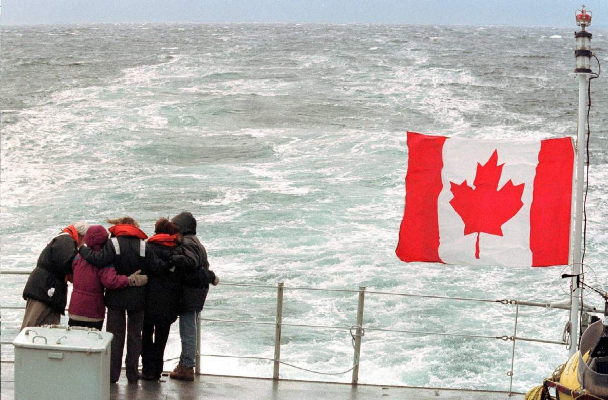 Family members of victims of the crash of Swissair Flight 111 embrace as they pay respects on the deck of HMCS Goose Bay at the crash site off the coast of Nova Scotia on Nov. 28, 1998.