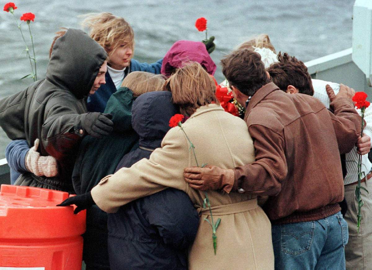 Family members of victims of the crash of Swissair Flight 111 embrace as they pay respects on the deck of HMCS Goose Bay at the crash site off the coast of Nova Scotia on Nov. 28, 1998.
