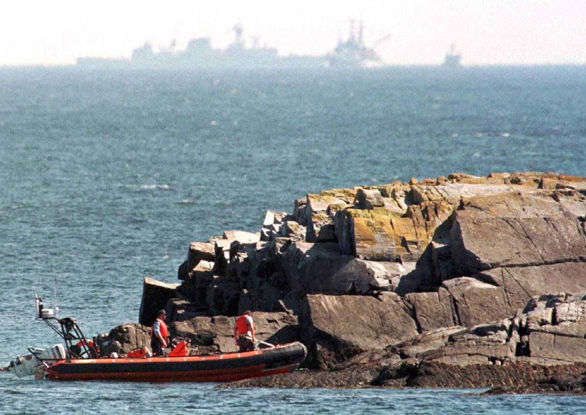 Searchers check the coastline near Bayswater, N.S., on Sept. 16, 1998, as USS Grapple and HMCS Halifax continue their recovery work at the crash site of Swissair Flight 111.