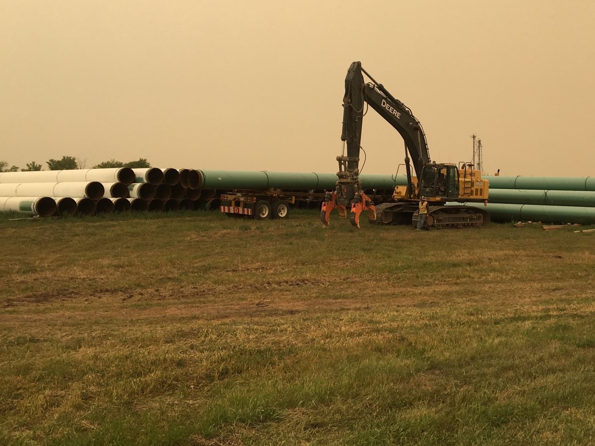 Machinery sits next to some of the pipeline that will be used in Line 3's reconstruction. 