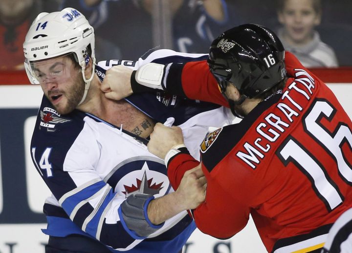 Winnipeg Jets' Anthony Peluso, left, fights Calgary Flames' Brian Mcgrattan during first period NHL hockey action in Calgary, Alta., Thursday, Jan. 16, 2014.